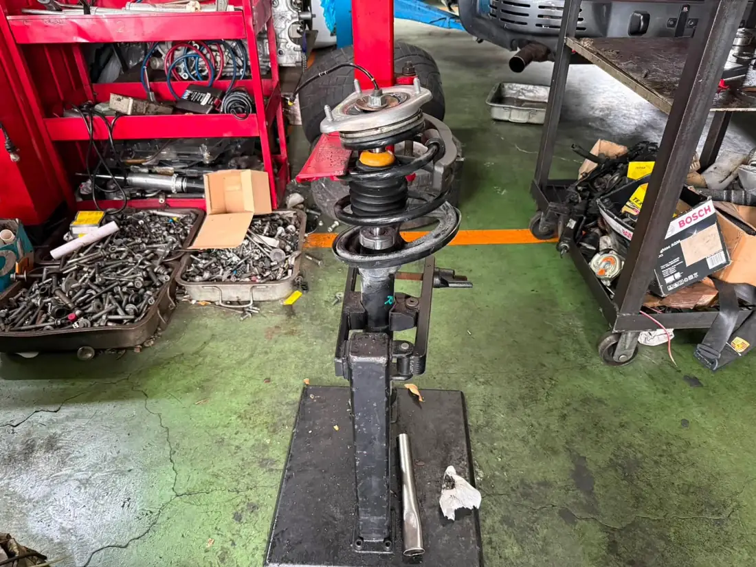 997.2 Turbo S 前避震器總成架在彈簧壓縮器上拆解