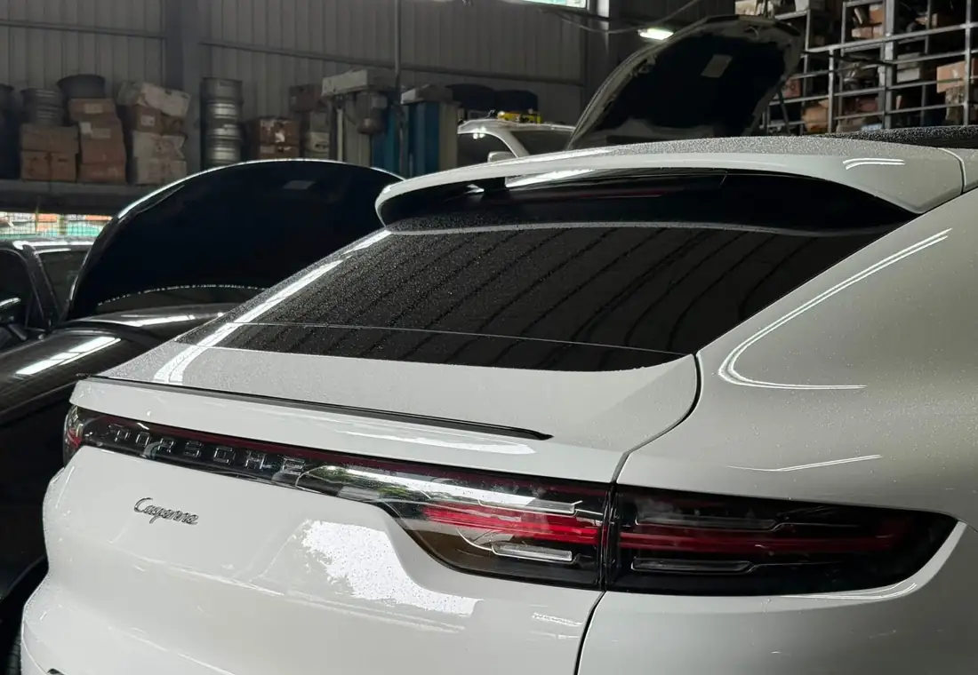 白色 Cayenne E3 Coupe 停在速必威廠內的車尾
