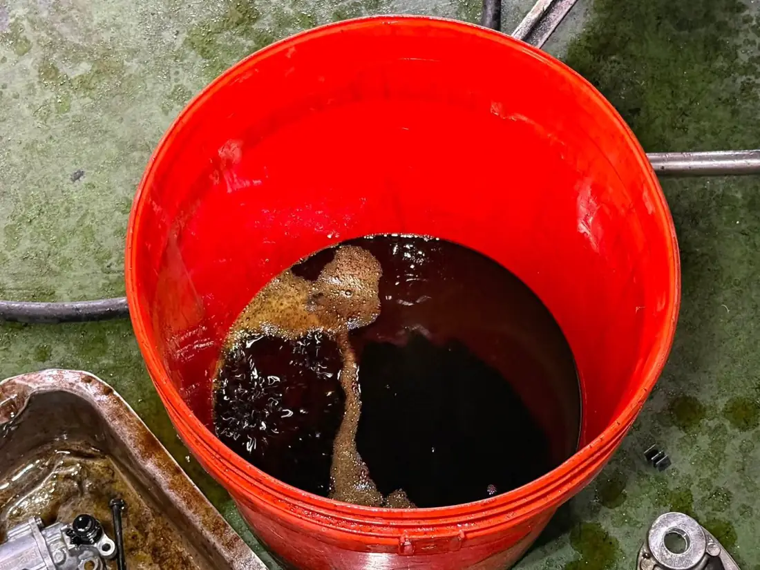 Cayenne E3 放出的變速箱油顏色偏深，盛在紅色油桶裡