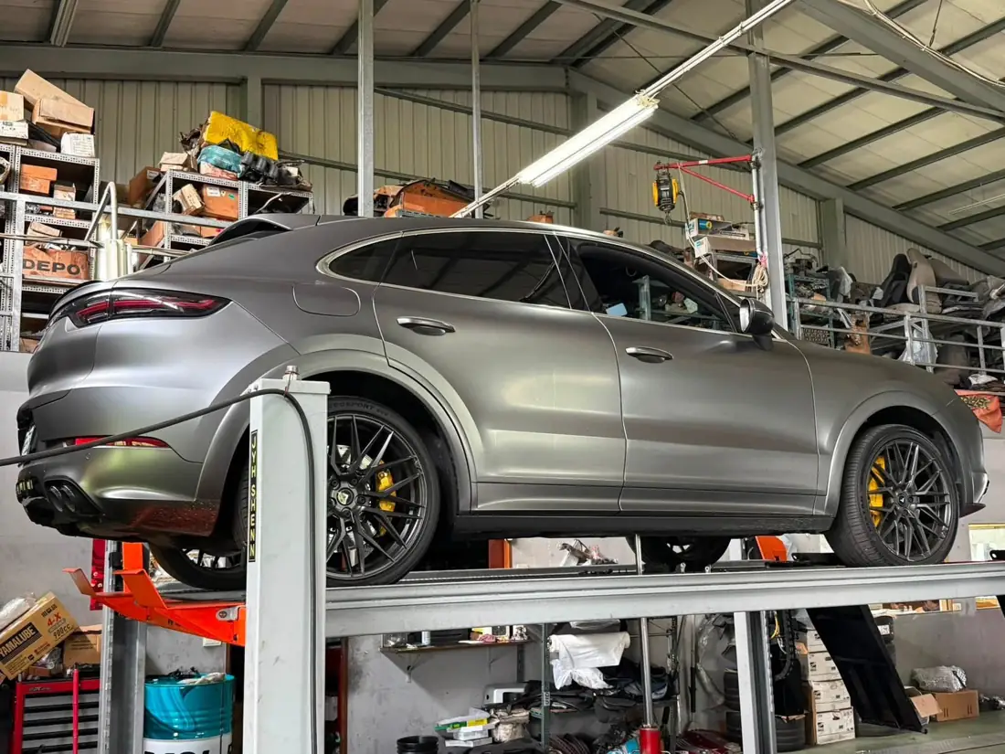 銀灰色 Cayenne E3 Coupe 架在速必威的舉升機上